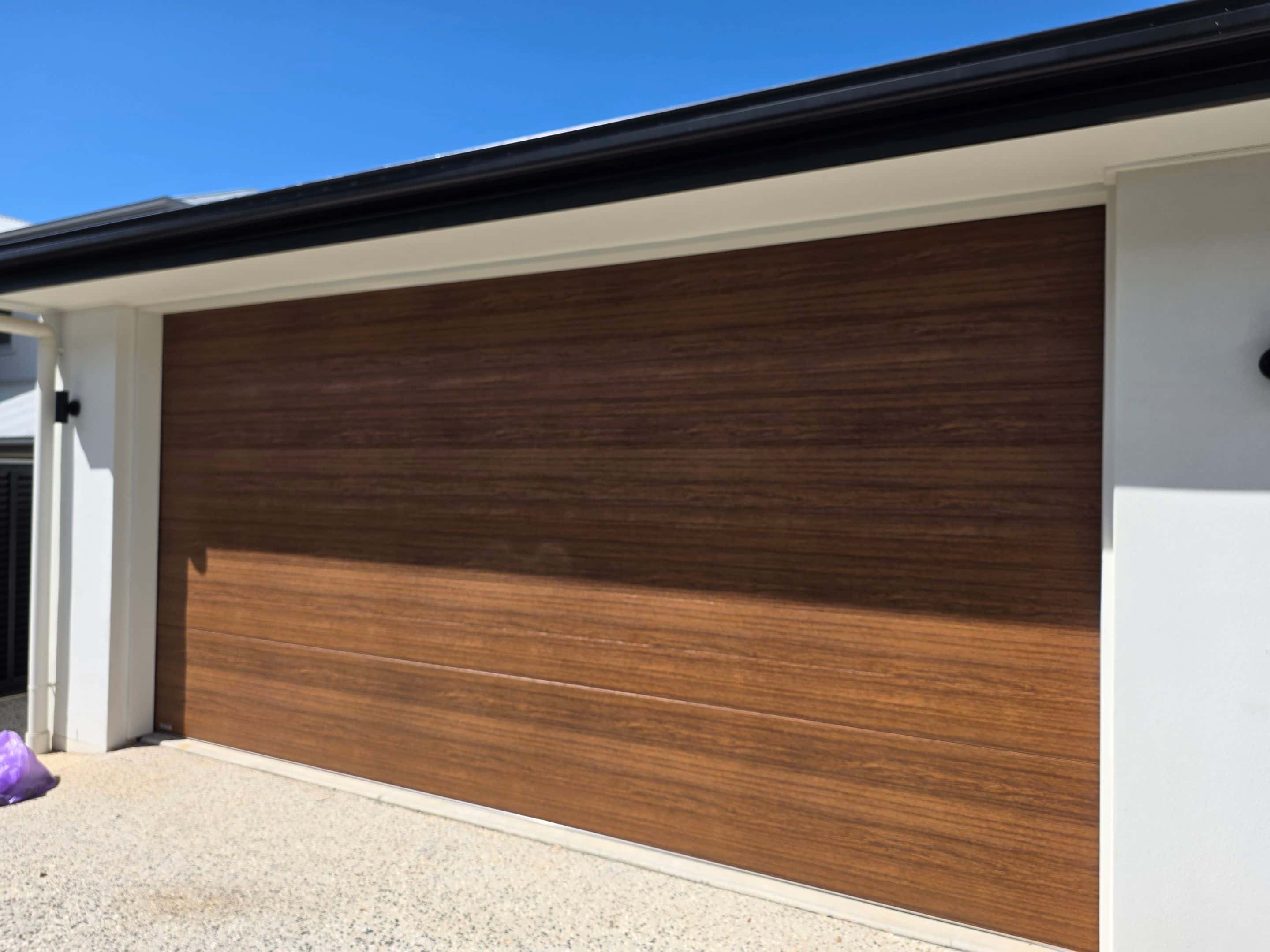 Woodgrain-look sectional garage door on a Sunshine Coast home